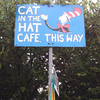Festivals on a budget - how to save money at festivals - Cat in the hat cafe sign at Glastonbury Festival